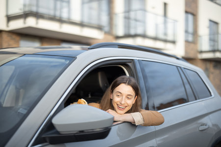 Happy woman eating a burger in the car