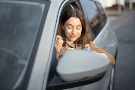 Beautiful woman eating salad in the car