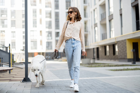 Woman walking with her big white dog on the street