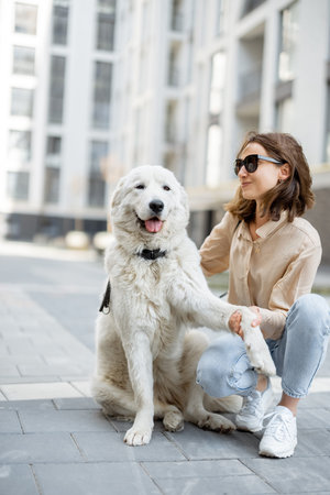 Woman walking with her big white dog on the street
