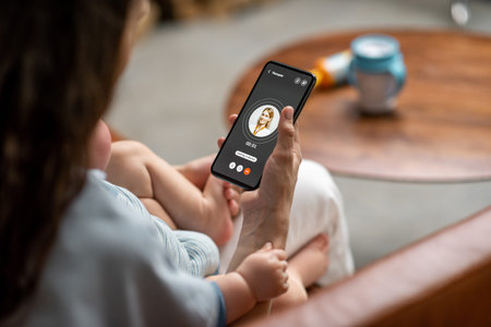 Young mother with newborn kid making video call