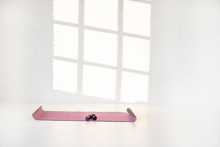 Fitness mat with dumbbells at white room. Sports equipment for fitness or aerobics. image with copy spaceの写真素材