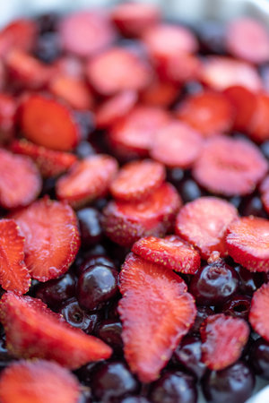 Sliced strawberry and cherry ready for baking for a summer cake, top view