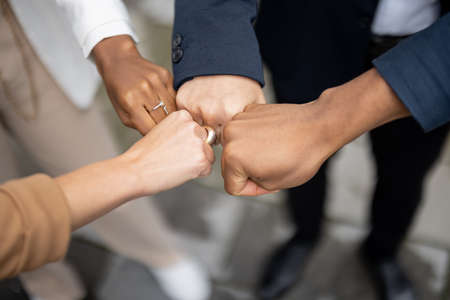 Cropped image of businessteam bumping fists each other on city street. Concept of modern successful business people. Idea of business cooperation. Remote and freelance work. Close up viewの写真素材
