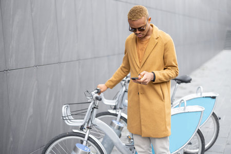 Man using smartphone app for bike rent. Concept of modern city transportation. Idea of online...