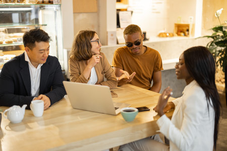 Multiracial business team talking and working in cafe or restaurant. Concept of remote and freelance...