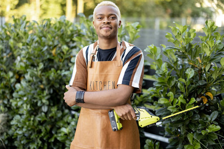 Portrait of a latin man as a gardener with gardening scissors in his yard. Concept of summer...