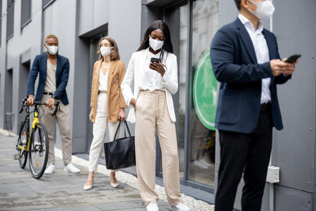 Multiracial businesspeople in medical masks waiting in queue on city street. Concept of business...
