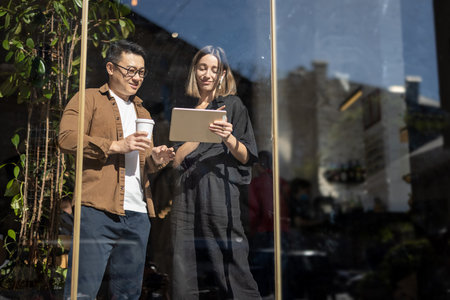 Multiracial business people watching something on digital tablet inside unknown building. Concept of...