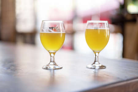 Bottom view of wooden table with alcohol cocktails at cafe. Concept of holiday, party and event. Modern interior. Sunny day. No peopleの写真素材