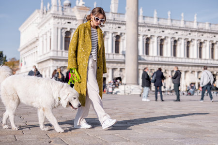 Young woman walking with dog on famous saint Marks square in Venice. Concept of visiting italian...