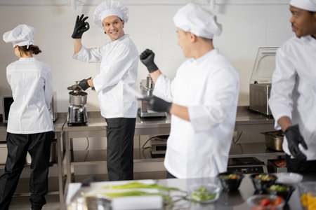 Happy chefs cooking in professional kitchenの写真素材
