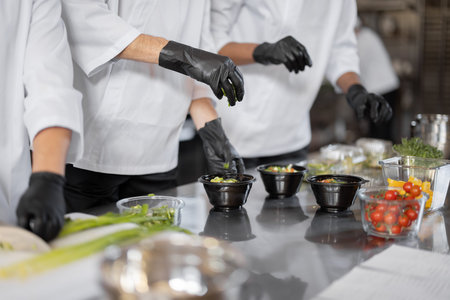 Chefs prepare takeaway food in professional kitchen