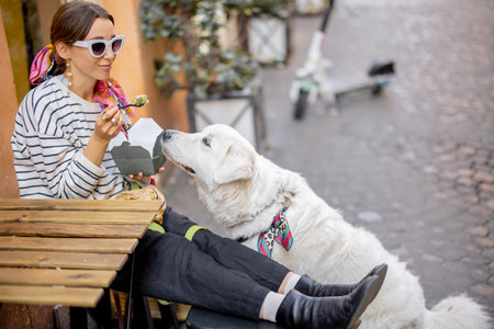 Woman cares her dog while eating pasta at outdoors cafe in Rome city. Concept of italian lifestyle,...
