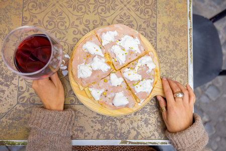 View from above on italian pizza with mozzarella and red wine at restaurant outdoors. Concept of...