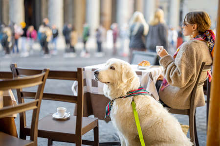 Woman sitting with her dog at outdoor cafe near famous Pantheon temple in Rome. Idea of spending time in Rome. Concept of italian lifestyle and travelの写真素材