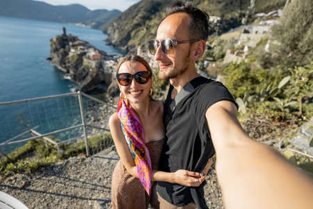Selfie photo of couple on background of mediterranean coast in Italy. Traveling famous Cinque Terre region in northwestern Italy. Vernazza villageの写真素材