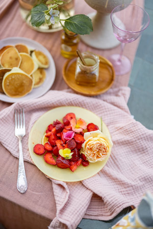 Breakfast on beautifully decorated table with flowers in gardenの写真素材
