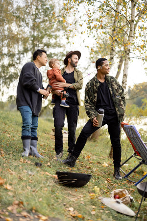 Smiling multiracial male friends resting in nature at autumn. Concept of leisure, weekend and...