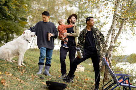 Pleased multiracial male friends taking selfie on smartphone during rest in nature. Concept of...