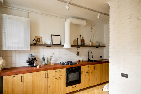Stylish kitchen interior of modern apartment made in white and beige tones with wooden kitchen front and floorの写真素材