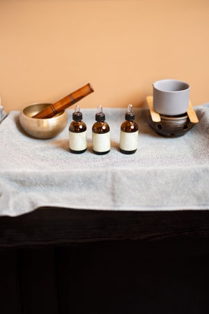 Essential oil for massage in jars and other props for massage on a towelの写真素材