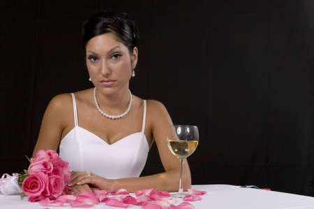 Bridal portrait over black background with pedals and champaign glassの写真素材