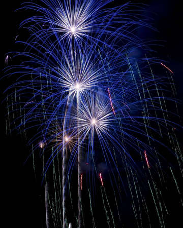 Multiple blue firework explosions during celebrationの写真素材