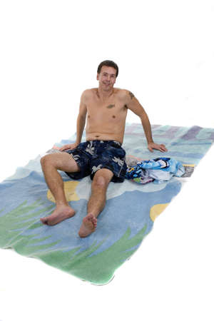 Adult male in swimming suit and beach towelの写真素材