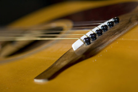Close up of one end of a string guitar