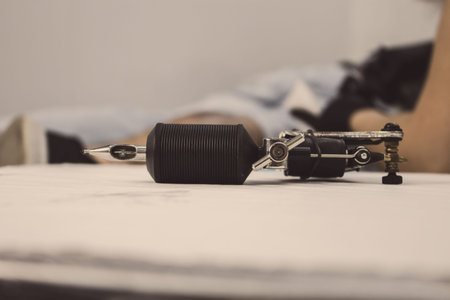 Tattoo machine close up resting on the clean table.