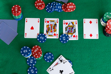 Aerial view of a poker game with community cards, poker chips and a strong hand of ace and king of...