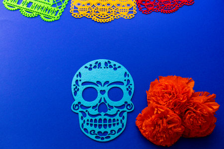 Traditional Mexican Day of the Dead setup featuring vibrant papel picado banners, a blue sugar skull...