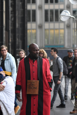 Vertical shot of the Cathedral servant in front of Cologne Cathedral in a red robe, Cologne, Germanyのeditorial素材