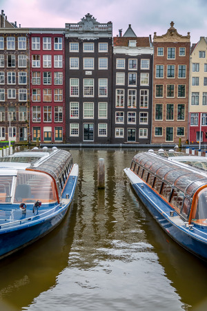 Canal boats offer tours of historic waterways in Amsterdam.の写真素材