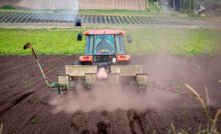 A farm tractor plows a field in British Columbia, Canada.の写真素材