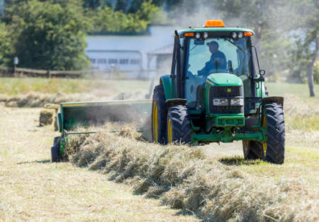 Victoria B.C. Canada- June 25/2020; A farmer uses tractors and other farm equipment to bale hay for use in the future.のeditorial素材