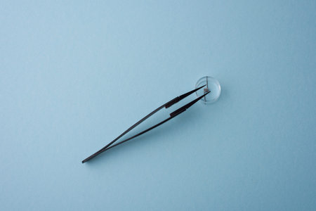 Coil and tweezer for vaping, background blue
