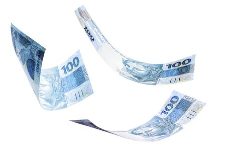 banknotes of one hundred reais from brazil falling on isolated white background. Concept of falling money, devaluation of the real or financial crisis.の写真素材
