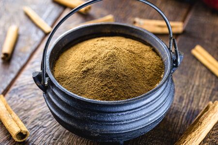 powdered cinnamon, ground in a Brazilian metal pot. Canela do brasil, grown in rio de janeiro and northeast of the country.の写真素材