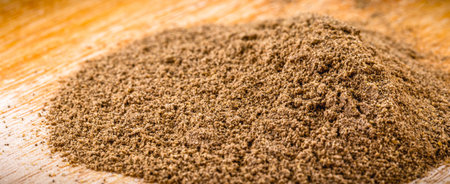 ground cinnamon powder used in cooking on rustic wooden background.