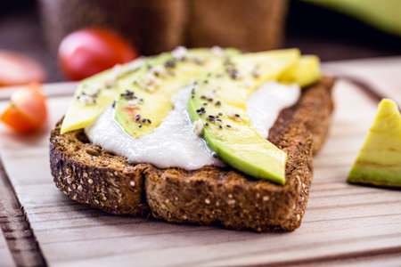 Tasty avocado sliced â€‹â€‹on crunchy rye toast, with cream, grains and spices. Vegetarian...