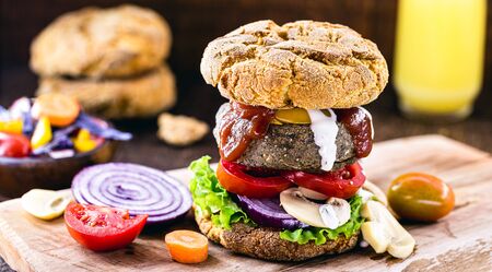 vegan snack, meatless hamburger, vegetarian food based on plants and proteins, with organic ketchup and white herbal sauce. Healthy food.の写真素材