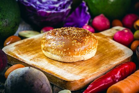 sweet bread surrounded by vegetables on kitchen board, healthy hamburger bread.の写真素材