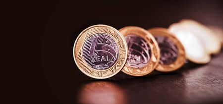 images of one real coins, money from brazil on isolated black background. Falling real of the Brazilian real, stock exchange loss.の写真素材
