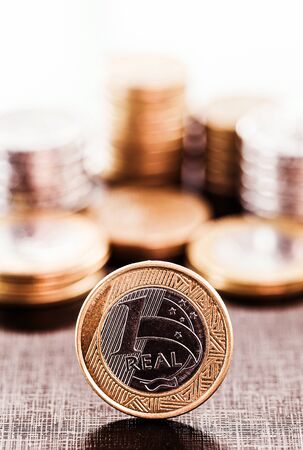 currency of a Brazilian real, with blurred image in the background of several currencies. Award, savings, economy and wealth concept.の写真素材