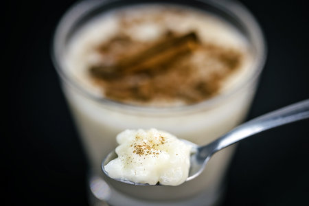 Spoon with rice pudding and cinnamon. Typical dessert from Brazil, a tasty porridge.