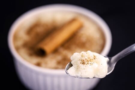 Spoon with rice pudding and cinnamon. Typical dessert from Brazil, a tasty porridge.の写真素材