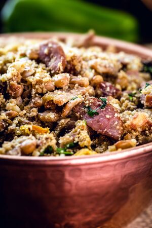Beans with pork, called tropeiro beans, typical Brazilian food, state of Minas Gerais. Copper pot on rustic wooden background.の写真素材