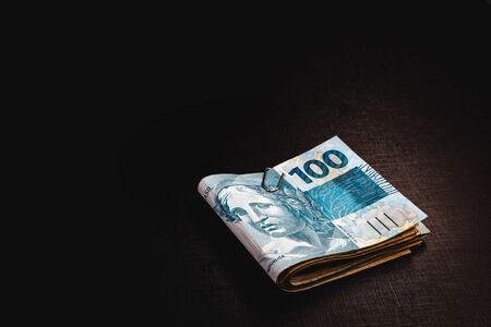 Brazilian money pack on isolated black background. Money from Brazil, called REAL, together on a black table. Concept of financial value or withdrawal from FGTS, banking.の素材 [FY310150150897]